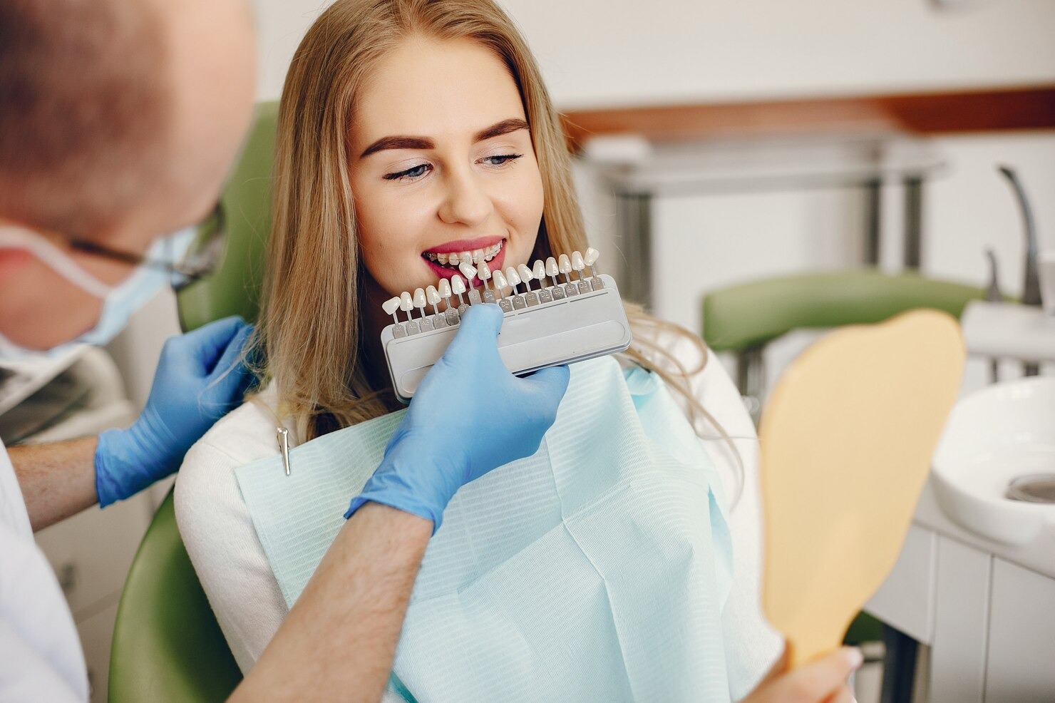 Woman in dental chair learning about dental implants near me prices